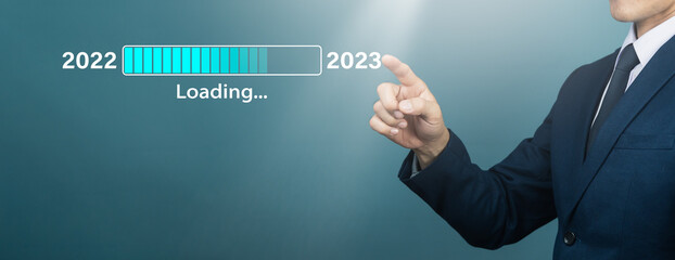 On New Year's Eve, a businessman taps a virtual download bar with a loading progress meter,...