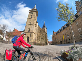 Öhringen. Baden-Wuerttemberg, Germany, 03-14-2022, woman on bicycle tour in downtown of Öhringen,...