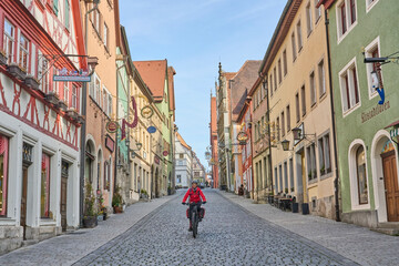 woman on bicycle tour in downtown of Rothenburg on Tauber, one of the most famous  medieval cities in Germany 