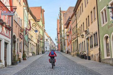 woman on bicycle tour in downtown of Rothenburg on Tauber, one of the most famous  medieval cities in Germany 