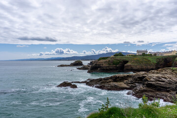 Fototapeta na wymiar coastline in Galicia near Foz with green meadows and homes on the seashore