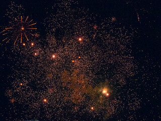 A Scattering of Bright Holiday Fireworks Lights Lit Up the Black Night Sky