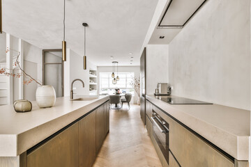 Interior of modern spacious kitchen with built in appliances and dining zone