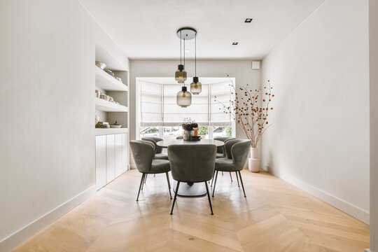 Minimalist dining room interior with round table and soft chairs