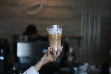 Closeup of Iced Caramel Macchiato at the coffee shop, Caramel Macchiato is a classic macchiato beverage. It consists of vanilla syrup, espresso, steamed milk, foam, and caramel drizzle