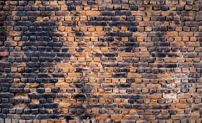 Close up photo of rustic and retro styled brick wall texture background. Old dark and black stained pattern design.