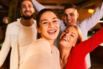 Group of young people having fun in a night out in club and taking selfie