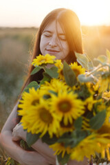 Beautiful woman holding sunflowers in evening meadow. Tranquil atmospheric moment in countryside....