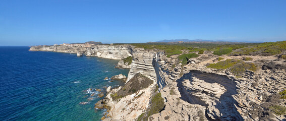 Bonifacio- Corsica coastline with limestone cliff overlooking the sea on clear blue sky