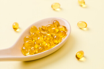 Close up of  oil filled capsules on spoon suitable for: fish oil, omega 3, omega 6, omega 9,  vitamin A, vitamin D, vitamin D3, vitamin E - Image