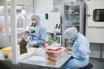 Women work in the lab. Conducts experiments on vaccines.