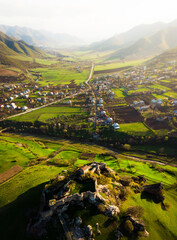 Aerial static view Kveshi fortress with with georgian flag and cross on top in spring. Historical...