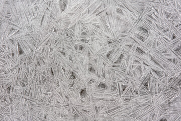 Ice on frozen river forming crystal like structures, closeup macro detail from above - abstract winter background