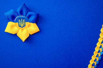 Ukrainian flower trident symbol isolated on blue. Yellow blue banner background, flat lay, copy...