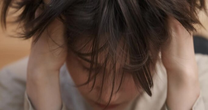 Nervous young woman grabs her head, feeling stress, strong emotions of despair and pain, suffering from psychological problem, regretting a mistake. Feels frustration and depression after wrong choice