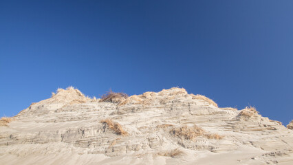 Fototapeta premium sand dunes with lines striped by the wind under blue summer sky in Zeeland the Netherlands