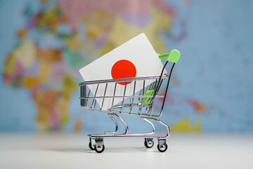 Japanese national flag in miniature shopping trolley cart. Shopping online or shipping, duty...