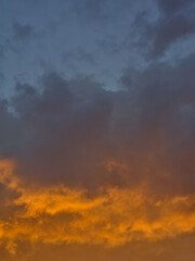 Naklejka na ściany i meble Colorful cloudy evenig sky in blue, orange and grey