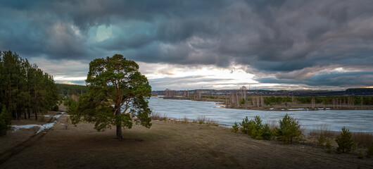 evening landscape with a forest on the bank of a frozen river, Russia, Ural in April