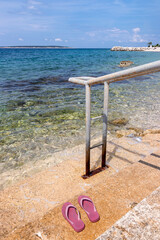 Treppe mit Flip Flops am Strand von Mandre, Insel Pag, Kroatien
