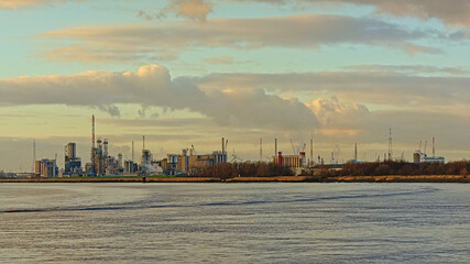 Fototapeta premium Industrial buildings along river Scheldt in the port of Antwerp, Flanders, Belgium