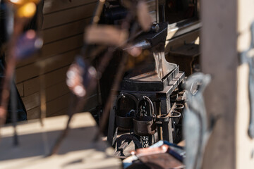 Blacksmith's workplace, forged metal buckets on an anvil framed by a blurred background. Rare professions, traditional blacksmithin