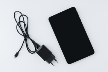 Black smartphone charger. White background.