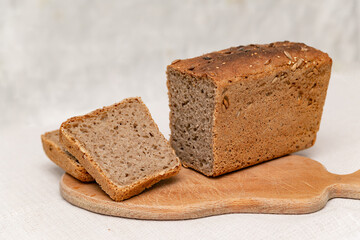 sliced rye bread on a wooden board on a white background