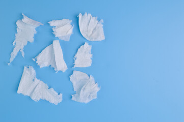 Torn tissue papers isolated on a blue background.