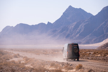 4x4 camper van photograph taken from behind on a dusty desert road in Iran