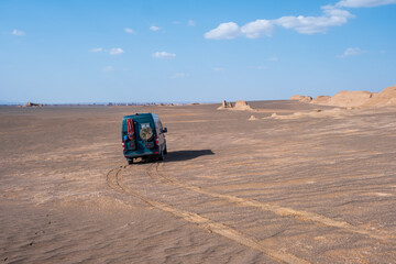 Campervan in the middle of desert at sunset