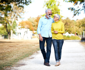 portrait of a senor couple walking in park
