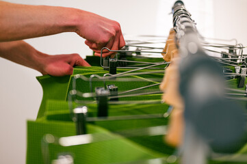 Vibrant green exercise mats hanging on clothes hangers in a row, man's hands picking one from the group