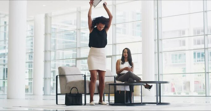 Ill show you whos boss.Businesswoman breaking a laptop in a a modern office. Angry, stressed businesswoman breaking laptop, throwing documents while coworker looks shocked.