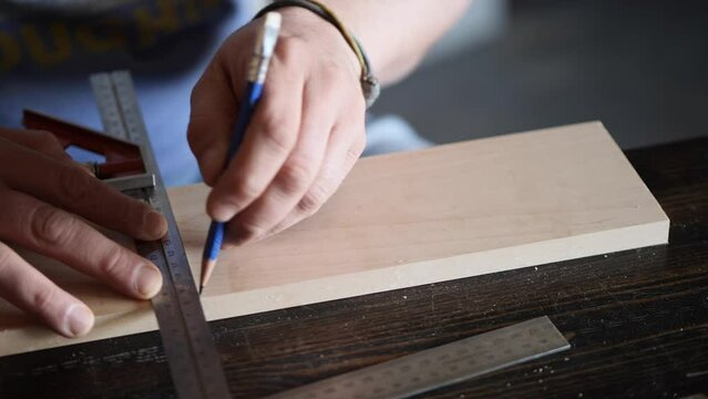 woodworker mark wood detail with square and pencil