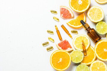 Vitamin C. Anti aging cosmetic. Fresh citrus fruits with serum bottles, ampoules and pills. Top...