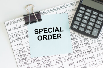 Special Order text on a blue card clip to the paper with reports next to the calculator on the table, business concept