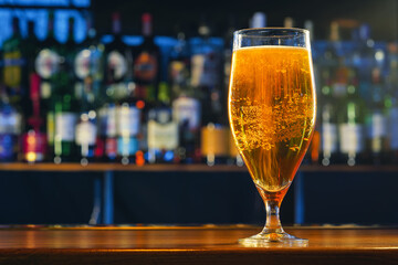 Fresh cold beer in glass on bar background