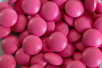 Lots of pink round pills close-up, high resolution photo.