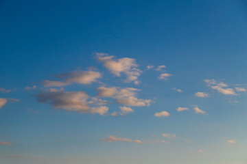 White cumulus clouds on a clear blue sky.