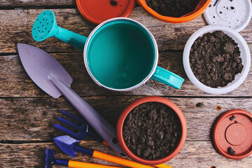 Flower pots, watering can and garden tool on a wooden background. © freeman83