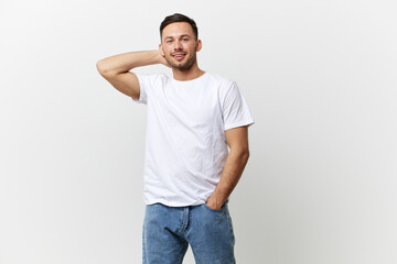 Smiling happy enjoyed young tanned handsome man in basic t-shirt hold hand behind head posing isolated on over white studio background. Copy space Banner Mockup. People emotions Lifestyle concept