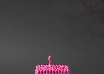Pink cotton swabs stand flat on a gray background, one above all the top view of the concept of...