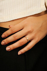 Close-up of an elegant engagement diamond ring on beautiful woman's finger. love and wedding concept. Like the split tone Instragram process.