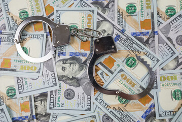 metal handcuffs on dollars background
