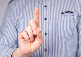 Man with index finger raised upwards. Forefinger pointing to top. Attention, count gesture. High quality photo