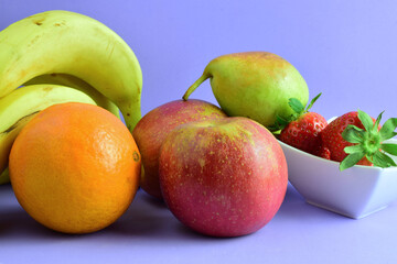 Varied fruit, to complement for a healthy diet. Mauve background.