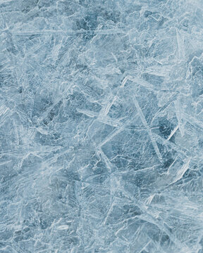 cracked ice close up, deep frozen lake blue ice texture, repeating pattern