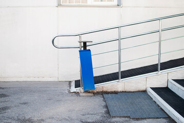 ramp to the house,stairs with black rubber coating,blue dumpster on the street