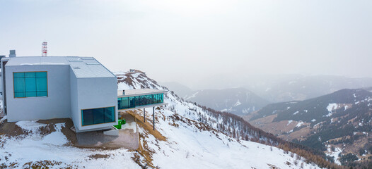 View of alpine museum and restaurant on snowy landscape. Panoramic sight of converted funicular...